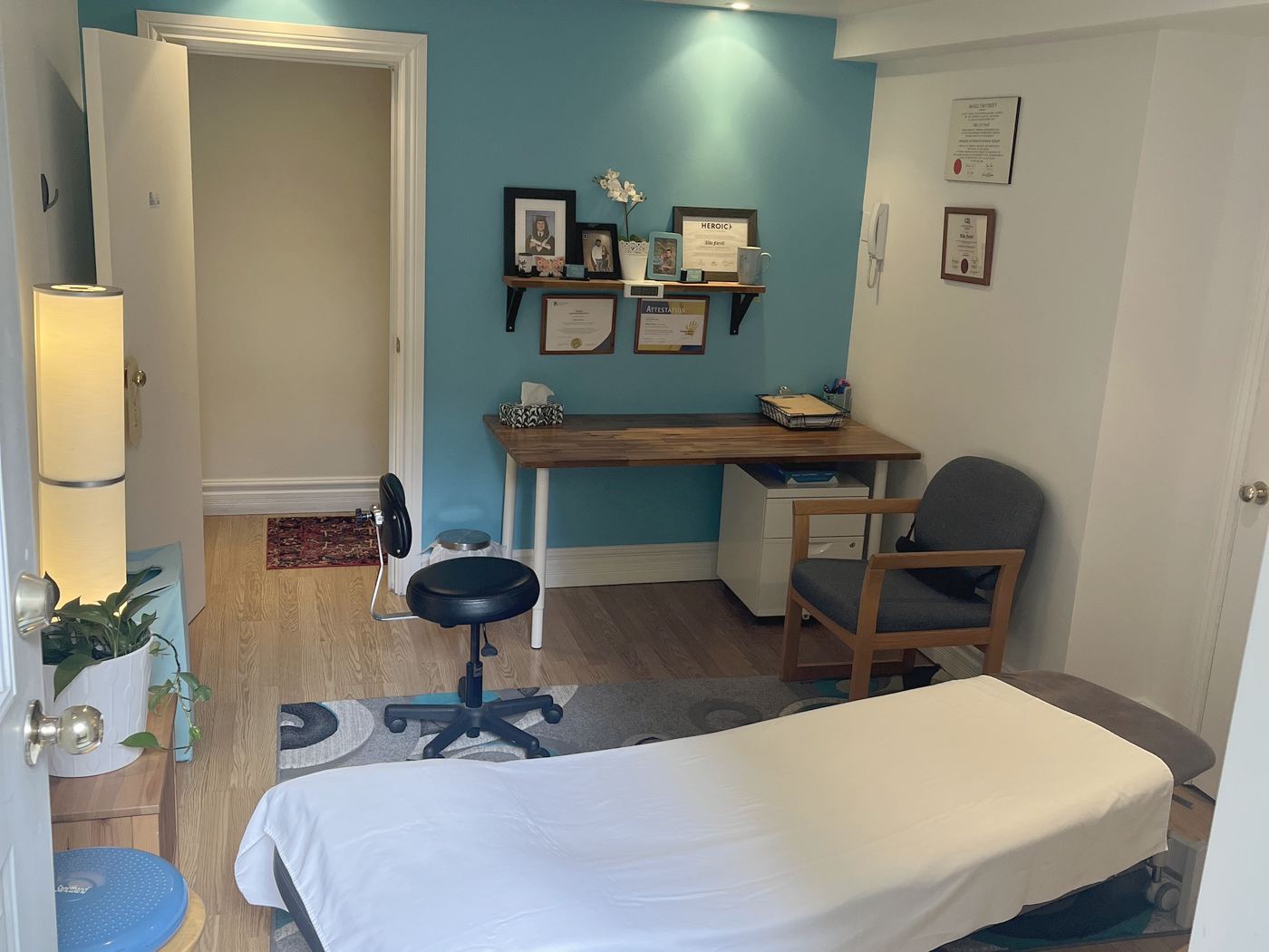 Alida's office: turquoise wall, wooden desk and treatment table