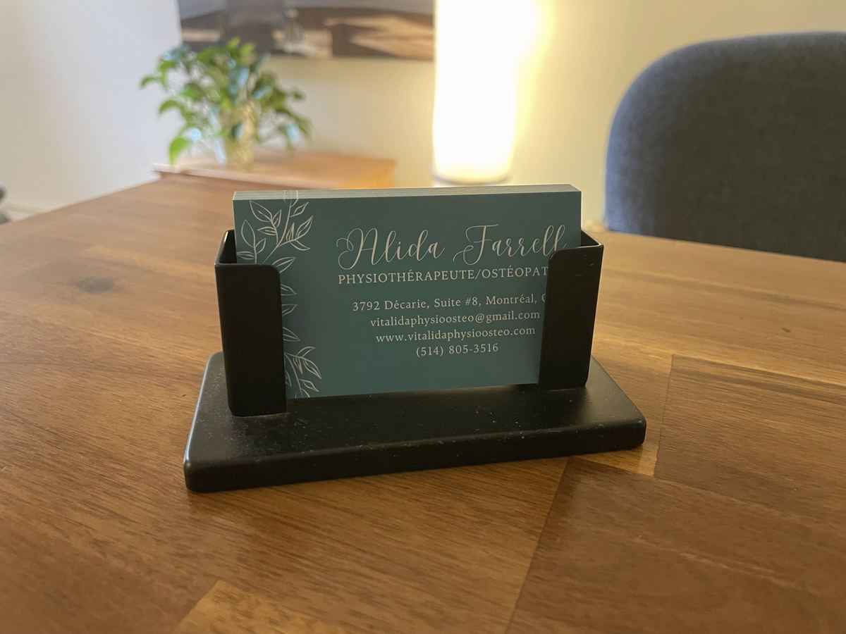 Ma carte d'affaires, turquoise à feuillage, posée sur une table de bois