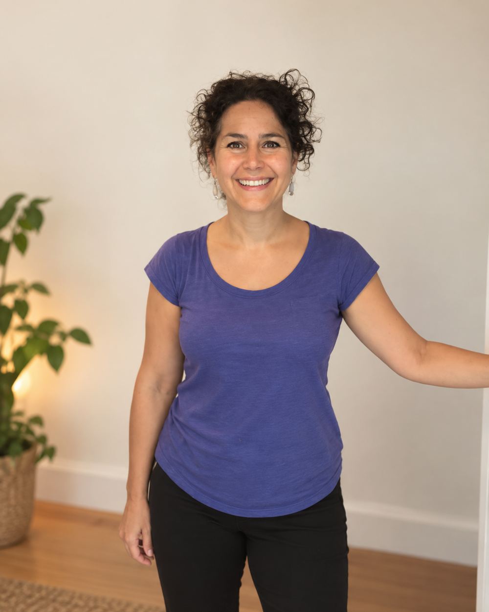Sharonne Cohen, debout dans une salle claire, en chandail mauve, qui sourit