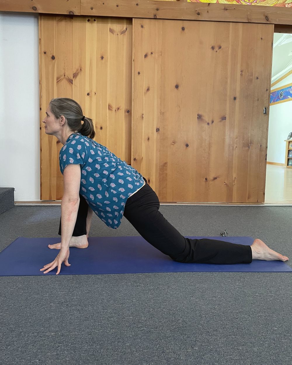 Alida Farrell in a low lunge on a blue yoga mat